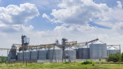 Grain elevator with steel silos on the background of sky