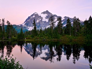 Reflection of mountain in calm water at sunset. Picture Lake and Mount Shuksan  at Mount Baker Ski Area. Cascade Mountains near Bellingham, Washington, USA.