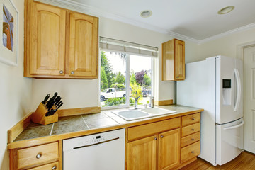 Kitchen room interior with wooden cabinets with marble tile counter top.