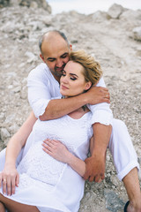 Pregnant woman and man photo shoot in a stone quarry