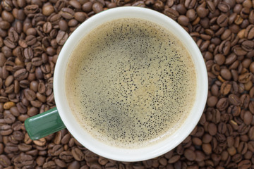 cup of coffee on the background of coffee seeds