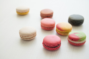 Colorful france macarons on white wooden background.