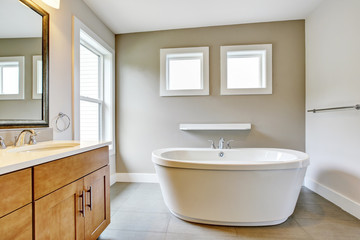 Fototapeta na wymiar Bathroon interior with vanity cabinet, two sinks and white bath tub.