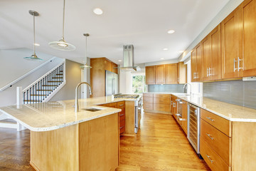 Kitchen room with wooden cabinets, granite counter top and island.