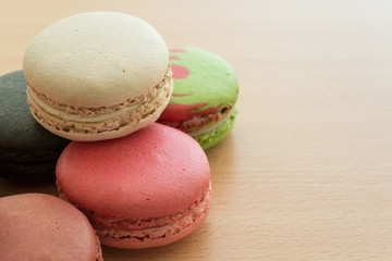 Colorful france macarons on wooden background.