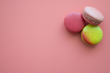 Colorful france macarons on pink background.