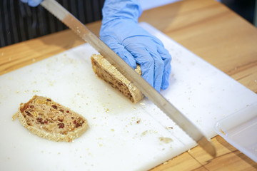 details cutting bread with knife in closeup
