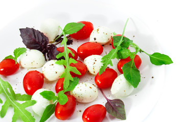 Tomatoes with mozzarella, arugula and basil.