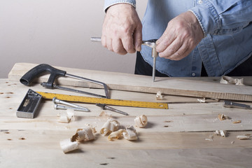 Carpenter working with plane on wooden background at Building Site. Joiner workplace
