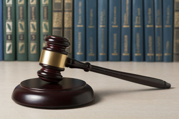Law concept - Book with wooden judges gavel on table in a courtroom or enforcement office.