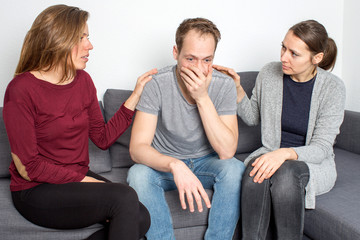 two woman helping a male friend