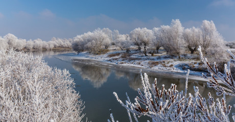 Bright winter scenery, with frozen river and trees on a cold and crisp, sunny, day