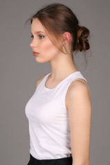 Girl standing profile. Close up. Gray background