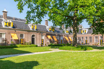 Green courtyard surrounded by old almshouses in Hofje van Staats in city of Haarlem, Holland,...