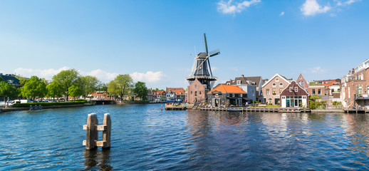 Panorama of Spaarne river with windmill Adriaan and waterfront cafe, Haarlem, Netherlands