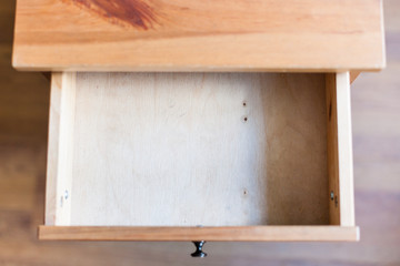 empty open drawer of wooden nightstand