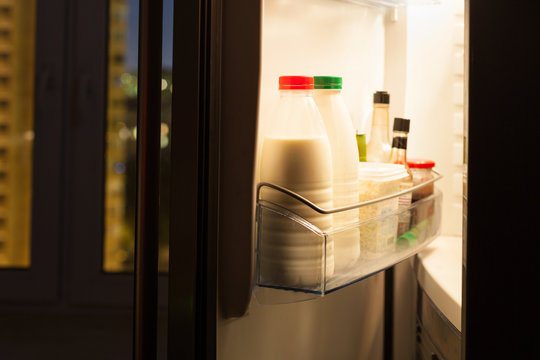 home fridge with dairy products in night