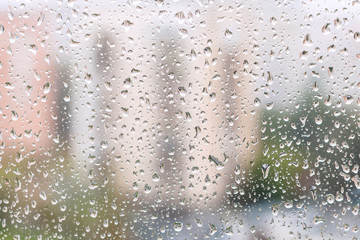 iew of rain drops on window pane of urban house