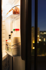 door of refrigerator with milk bottles in night © vvoe