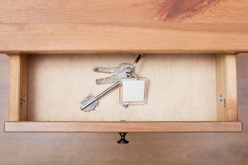 bunch of door keys with keychain in open drawer