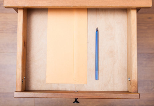 blue pen and envelope in open drawer