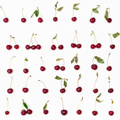 many ripe red cherries arranged on white