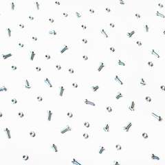 above view of little steel bolts and nuts on white