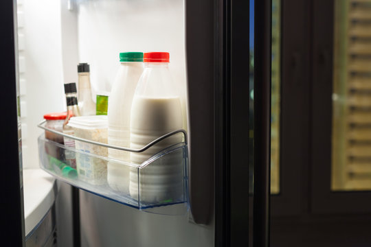 door of refrigerator with dairy products in night