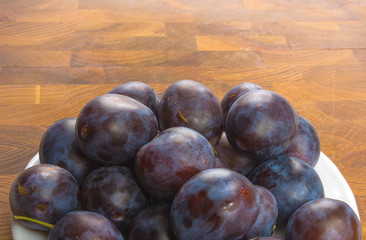 Fototapeta premium small plums on a white saucer