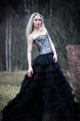 Fototapeta premium Portrait of beautiful girl in black dress in nature