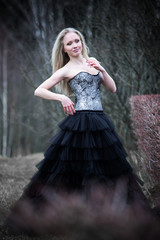 Portrait of beautiful girl in black dress in nature