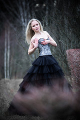 Fototapeta premium Portrait of beautiful girl in black dress in nature