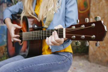 close up of a woman playing an acoustic guitar