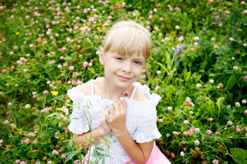 Portrait of beautiful little girl in white dress on the nature