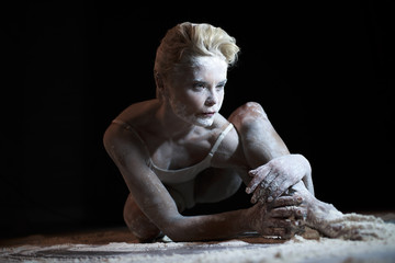 Portrait of beautiful woman lying on the floor with flour