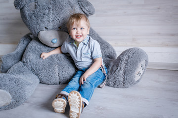 Portrait of little boy with a big toy bear in the Studio posing emotions