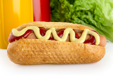 Hotdog with ketchup and mustard with salad in the background