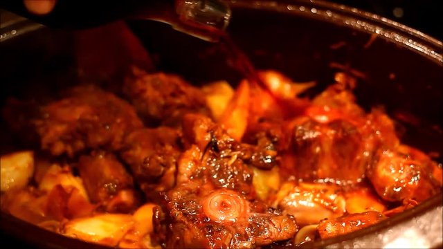 Adding red wine to the oxtail bourgignon
