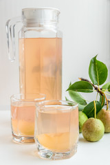 Грушевый сок и несколько груш на светлом фоне. Здоровое питание.