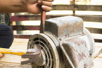 Old electric motor  and man working equipment repair on wooden floor background.Background craftsman or equipment.Zoom in