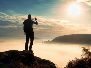 Amateur photographer takes impressive photos with phone. Hiker with backpack