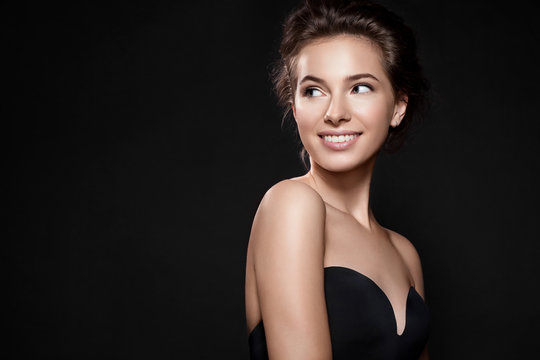 Fototapeta Beautiful woman with perfect smile and clean skin on black background