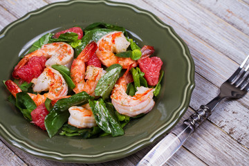 Shrimp, grapefruit and spinach salad in green plate