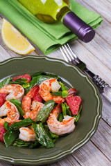 Shrimp, grapefruit and spinach salad in green plate
