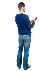 back view of business man uses mobile phone.    rear view people collection. Isolated over white background. backside view of person. bearded man in blue pullover is holding a smartphone and looking