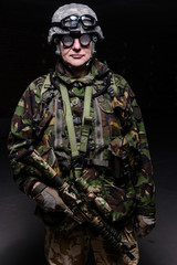 Soldier in helmet with rifle/Soldier in helmet, weird glasses with rifle on dark background