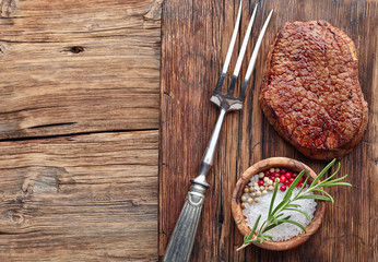 Beef steak on a wooden board with spices
