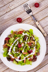 Chicken and red grape salad in white plate. View from above, top studio shot