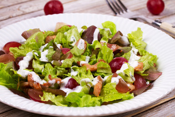 Chicken and red grape salad in white plate.
