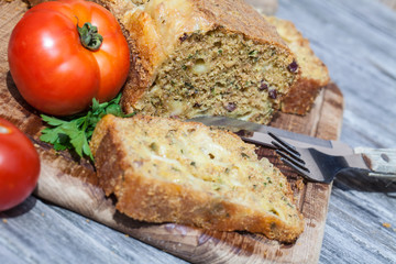 Deftiges Brot gefüllt mit Kräutern, Käse und Schinken, mit Tomaten angerichtet